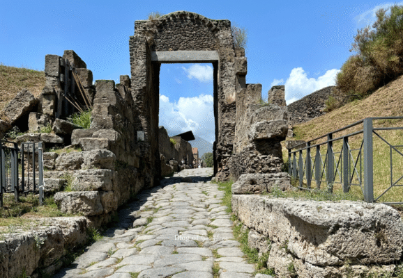Arch framing a historic road in the ruins of Pompeii, Italy.
