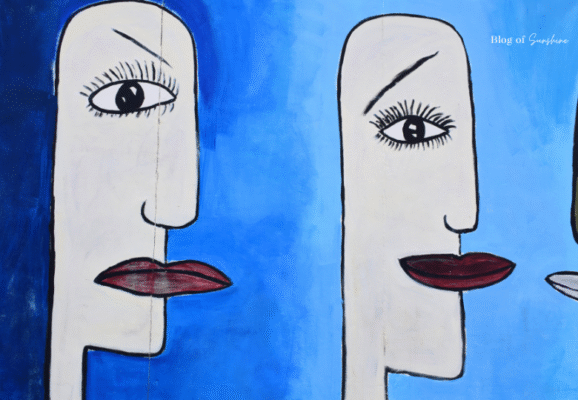 Close-up of abstract blue mural with stylized faces at the East Side Gallery