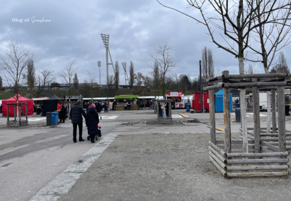 Visitors walking toward stalls at the Berlin flea market near the Berlin Wall Memorial and escape tunnel