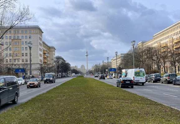 Wide view along Karl-Marx-Allee in Berlin with classic socialist architecture and Fernsehturm TV Tower in the distance
