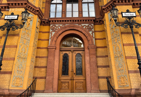 Ornate entrance of Berlin's historic Rotes Rathaus post office building with decorative brickwork and archway