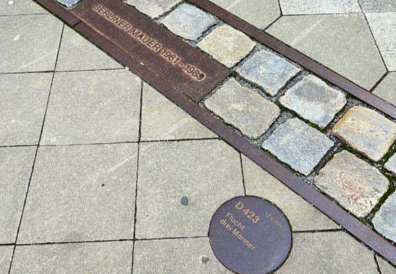 Berlin Wall memorial line on the pavement with marker D423 commemorating the escape of three men from East to West Berlin