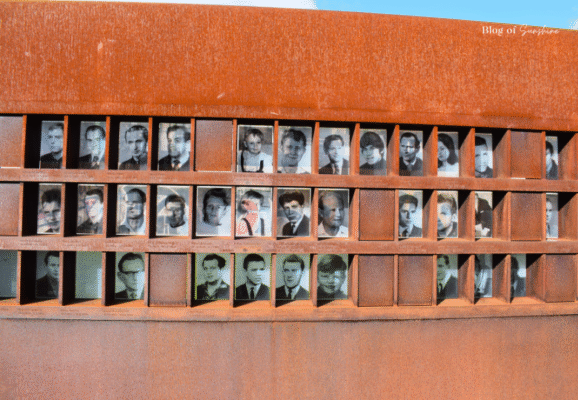 Portraits of people who died trying to cross the Berlin Wall, displayed in a rusted steel memorial at Bernauer Straße