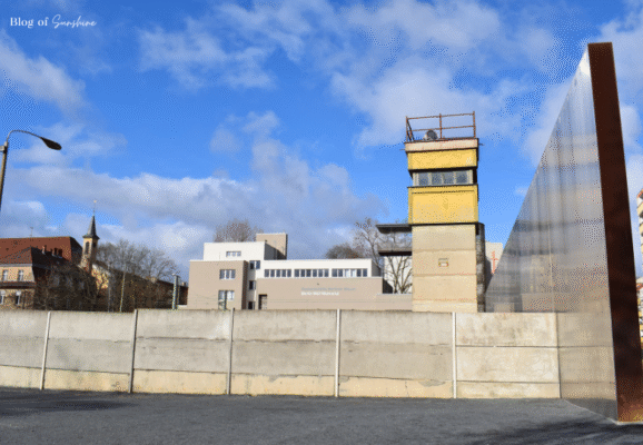 Historic watchtower and preserved Berlin Wall segment at the Berlin Wall Memorial, with death strip reconstruction
