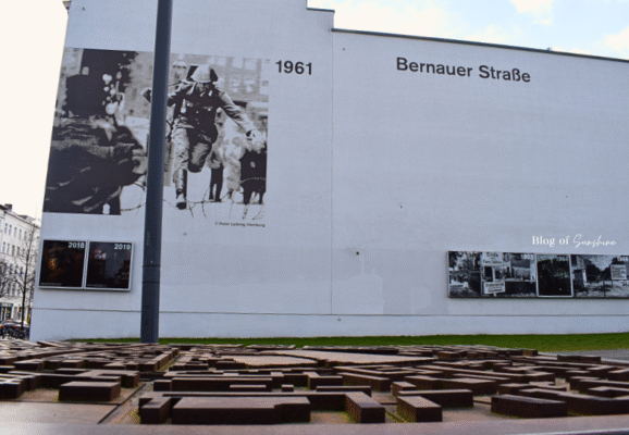 Berlin Wall Memorial at Bernauer Straße with Peter Leibing’s 1961 mural of a soldier jumping the barbed wire, and a bronze 3D city map in the foreground