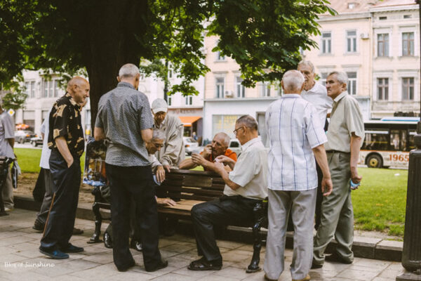 Group of elderly men playing chess under a tree in the small park opposite the Lviv Opera House on Svobody Avenue, Ukraine