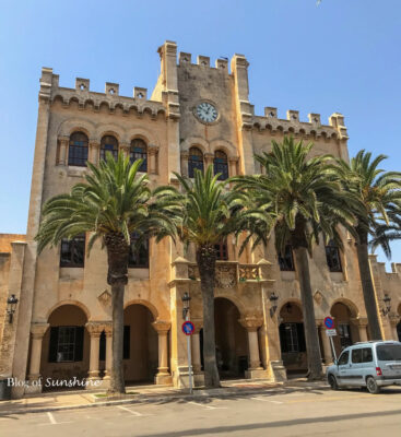 Historic City Hall building in Ciutadella, Menorca with palm trees and neo-Gothic architecture