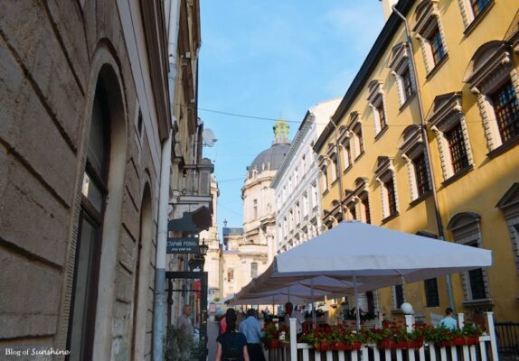 View of the Dominican Church dome from a narrow street in Lviv’s historic center, lined with cafés and colorful buildings