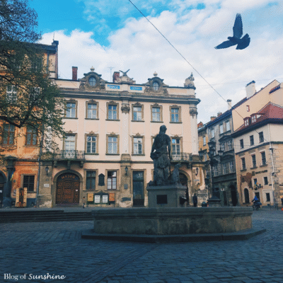 The Fountain of Diana statue in Rynok Square, Lviv, surrounded by historic buildings and cobblestone streets