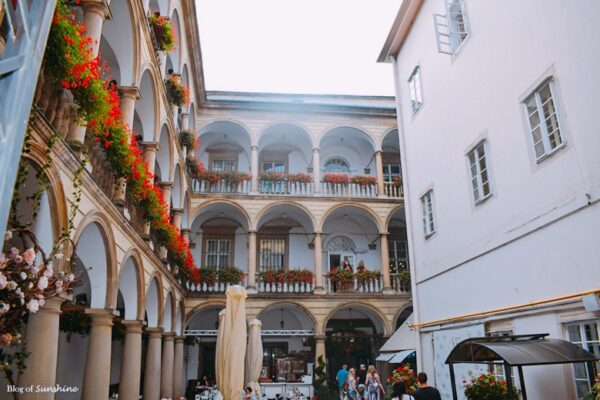 `The full view of the Italian Courtyard at Kornyakt Palace in Lviv, with arcaded galleries and flower-lined balconies
