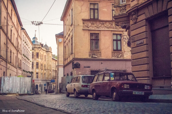 Quiet cobblestone street in Lviv’s Old Town with vintage Soviet-era cars and historic European architecture