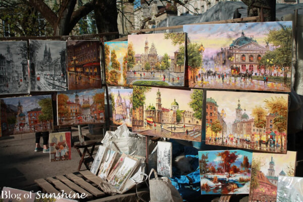 Paintings of Lviv landmarks and cityscapes on display at an outdoor street art market in Ukraine