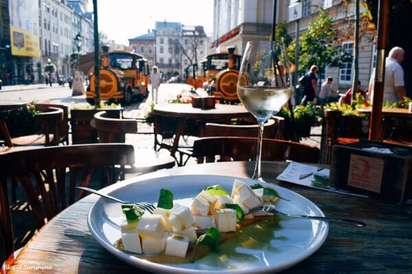 Cheese plate and glass of wine at an outdoor café near the Fountain of Diana in Lviv’s Rynok Square