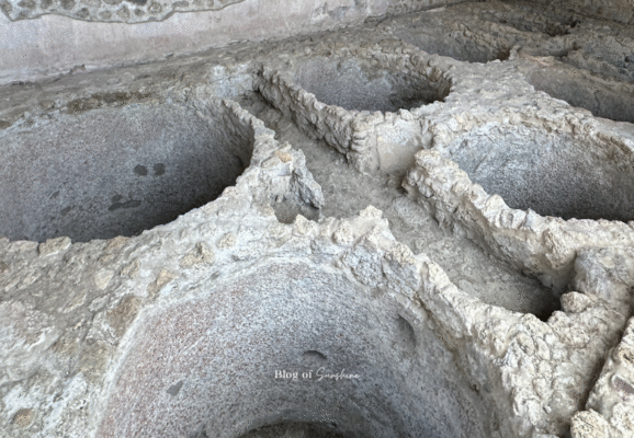 Interior of a Roman laundry and dye house in Pompeii, showing interconnected stone vats for fabric processing