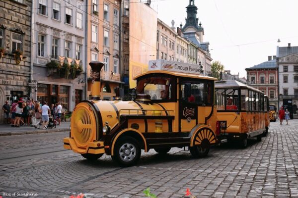 Tourist sightseeing train driving through Rynok Square in Lviv’s Old Town, Ukraine