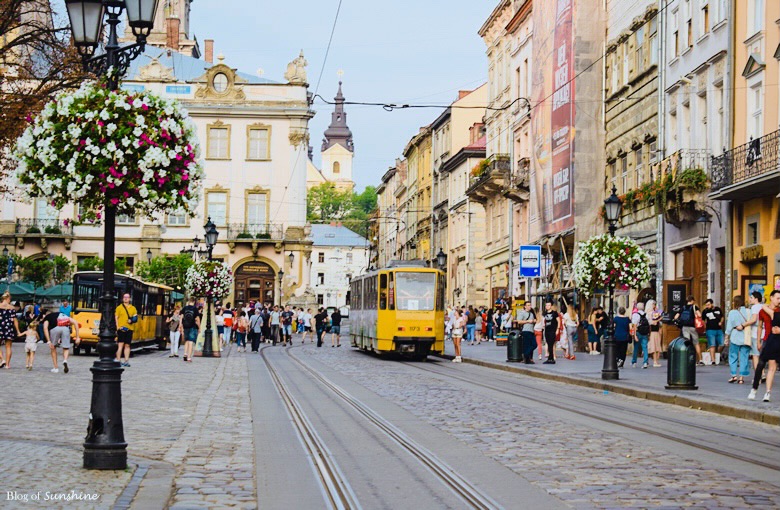 Yellow tram passing through Rynok Square in Lviv’s historic city center, surrounded by cobblestone streets and old buildings