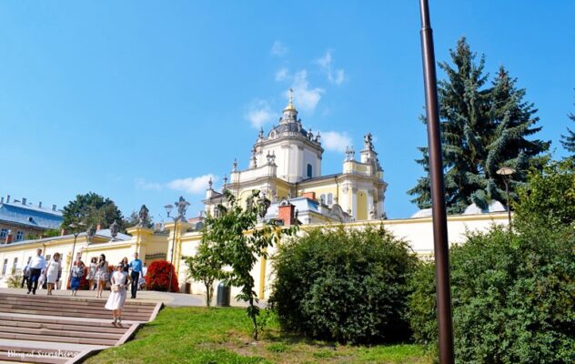 Wide view of St. George’s Cathedral in Lviv with visitors walking along the garden-lined entrance path