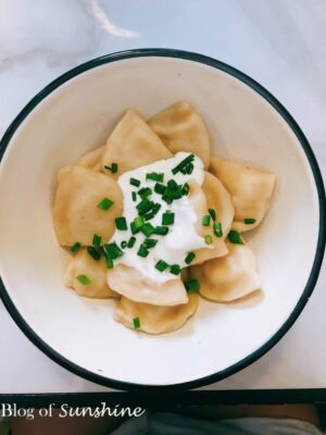 Traditional Ukrainian varenyky dumplings topped with sour cream and chopped chives, served at Marusia’s in Lviv