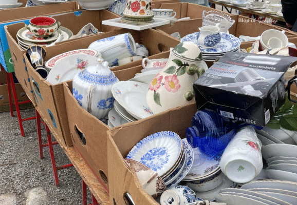 Cardboard boxes filled with vintage porcelain, crockery, and teapots at Berlin's flea market near Bernauer Straße