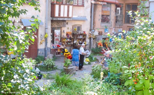 Two people exploring the Yard of Lost Toys in Lviv, a whimsical courtyard filled with stuffed animals and old toys