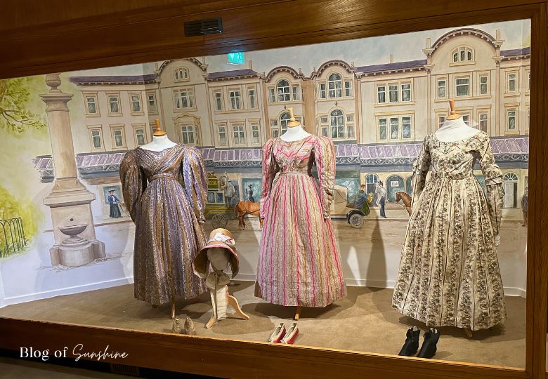 Three Georgian dresses with shoes and bonnet on display at Cliffe Castle Museum in Keighley