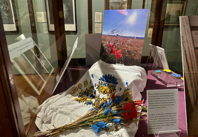 Ukrainian-themed display with a t-shirt and field photo telling the story of air raids, at Cliffe Castle Keighley