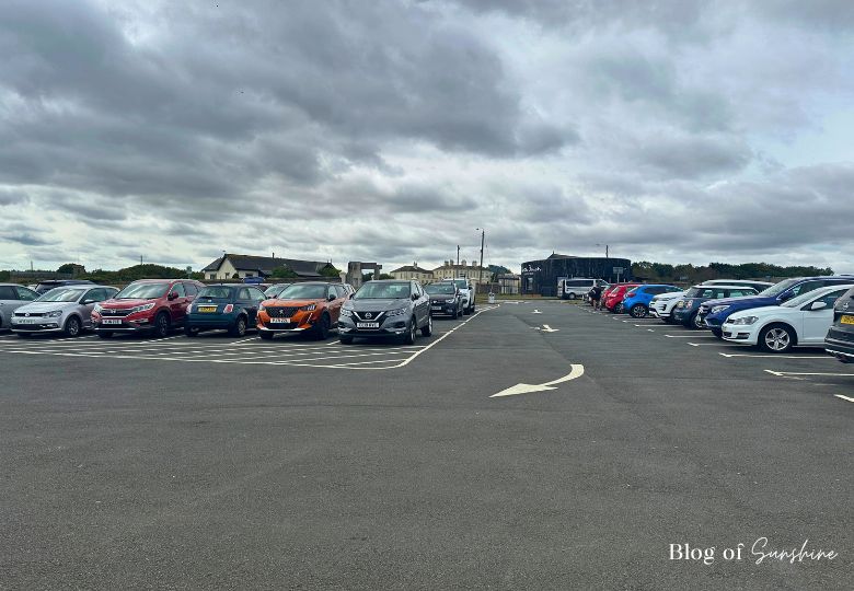 Wide view of Seaham Hall Beach car park with parked vehicles and nearby buildings including Seaham Hall Hotel