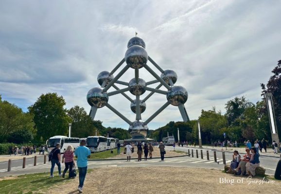 Front view of the Atomium in Brussels with tourists and tour buses in the foreground