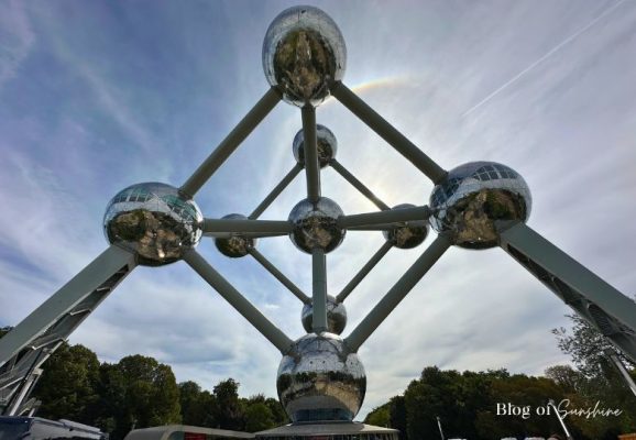 Looking up at the Atomium in Brussels from the entrance, with the sun shining behind the metallic spheres