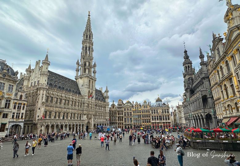 Crowds exploring Grand Place Brussels on a cloudy day