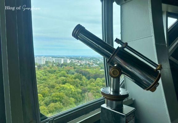 Brass telescope pointed toward the city skyline inside the Atomium observation deck