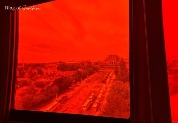View of Brussels through a red-tinted window from the top sphere of the Atomium