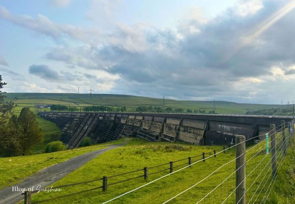 Wide view of Baitings Reservoir dam and surrounding moorland from the car park at the start of the circular walk