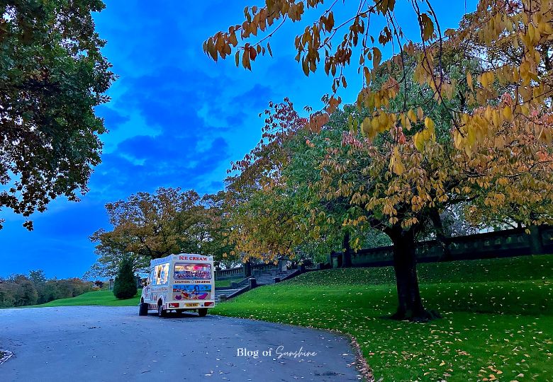 Ice cream van under autumn trees in Greenhead Park Huddersfield near the memorial steps