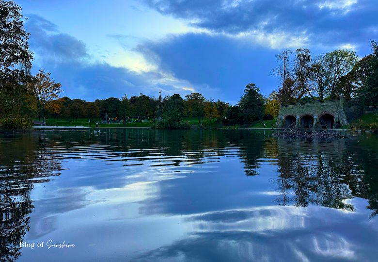 View of the pond and historic stone arches in Greenhead Park Huddersfield at dusk during autumn