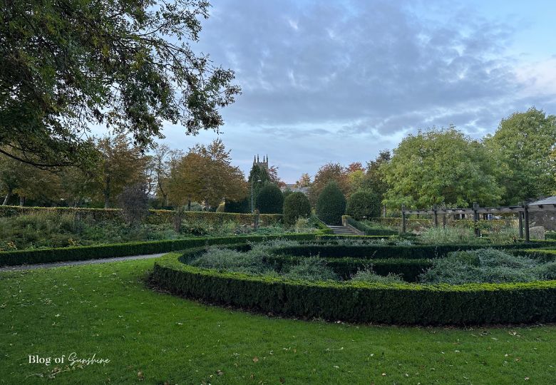 Autumn view of the rose garden in Greenhead Park Huddersfield with a distant church spire