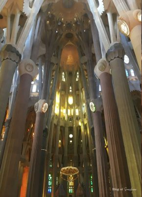 Central nave of the Sagrada Família with columns and golden stained-glass windows