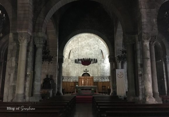 Romanesque crypt chapel inside the Sagrada Família with stone arches and altar
