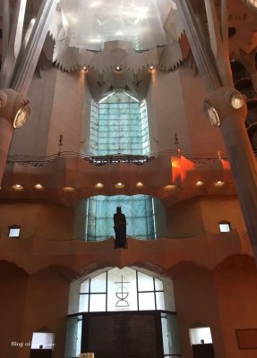 Eucharist chapel inside the Sagrada Família with cool blue windows and a crucifix statue