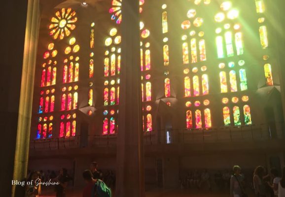 Fiery stained-glass windows of the Sagrada Família glowing in afternoon sunlight