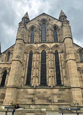Gothic west front of Hexham Abbey with tall stained-glass windows