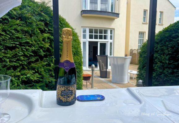 Champagne bottle on the edge of the hot tub outside Seaham Hall Garden Suite with the suite behind