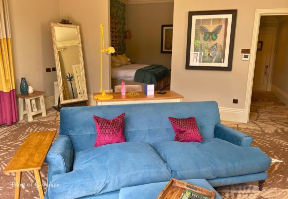 Lounge area in the Seaham Hall Garden Suite with Hot Tub featuring a large sofa, desk and bedroom area