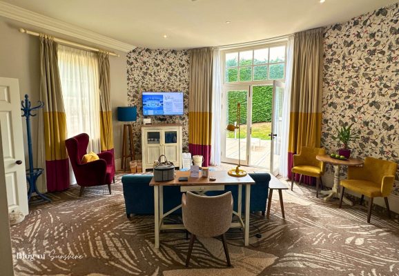 Wide view of the Seaham Hall Garden Suite lounge with TV and doors leading to the private garden