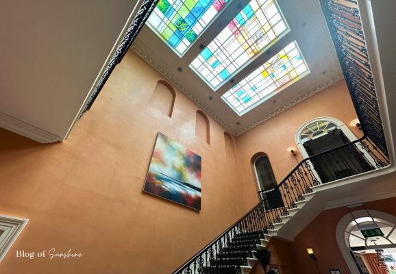 Atrium staircase at Seaham Hall Hotel with stained glass skylight ceiling
