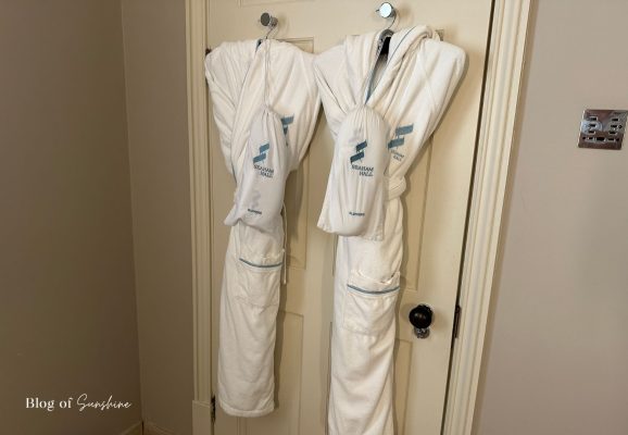 White Seaham Hall robes hanging on the bathroom door in the Garden Suite