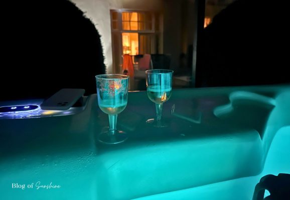 Private hot tub at night with two glasses outside the Seaham Hall Garden Suite