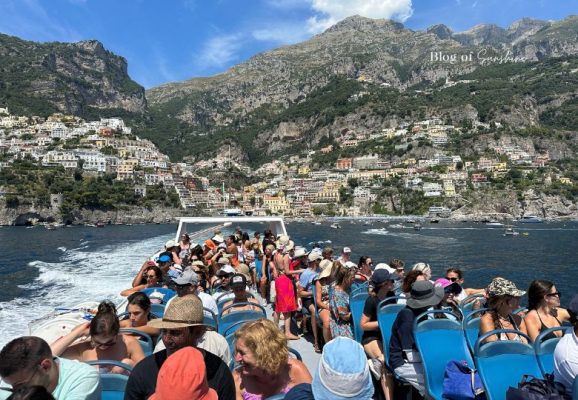 Amalfi Coast view from the water between Sorrento and Amalfi with boats and cliffside buildings
