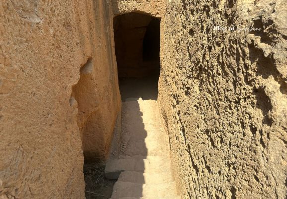Narrow stone steps leading into a rock-cut tomb at Tombs of the Kings in Paphos Cyprus