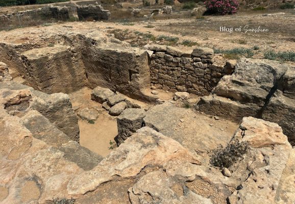 Rock-cut ruins and stone walls at Tombs of the Kings in Paphos Cyprus